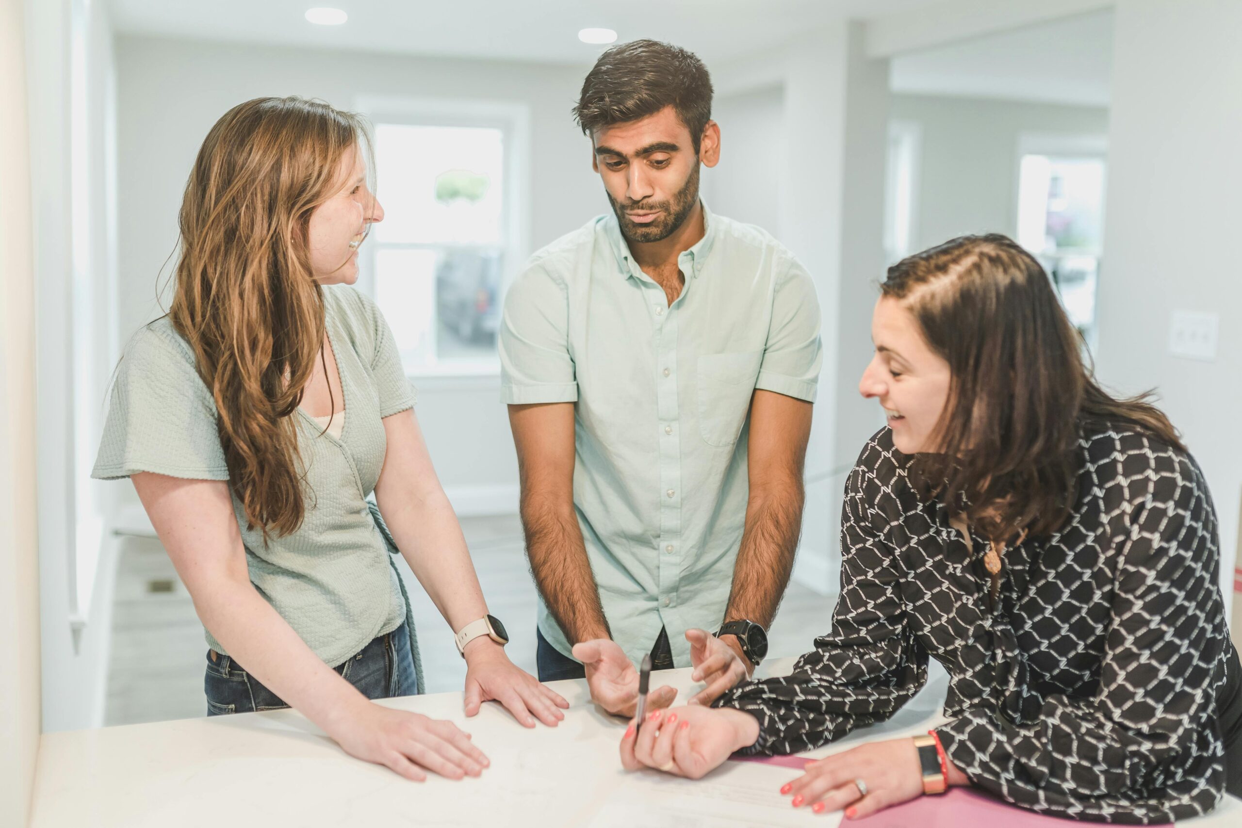 Three adults having a discussion about real estate in a modern home setting.